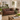 A classic brown leather Chesterfield sofa in a beautifully styled, rustic living room with a green sideboard, wooden coffee table, and potted plants.