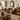 Brown leather Chesterfield 2 seater sofa in bright farmhouse living room with carved Indian mirror