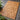 Natural Teak woven mat on a gray tiled floor with green plants.