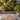 Tropical plants in a garden setting with Large Teak Mat in multiple tones resembling pebble colours