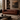 A brown leather sofa with vertical channel tufting, styled in a rustic, warm toned living room