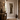 Sumatran wall mirror with an ornate carved white frame, displayed in a rustic boho-style hallway with a wooden console table, woven rug, and ceramic vases.