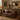Aged leather Chesterfield loveseat sofa in a styled living room setting with an indionesian mirror on the wall
