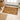 Small Natural Teak doormat on a wooden floor with shoes and a basket in the background.
